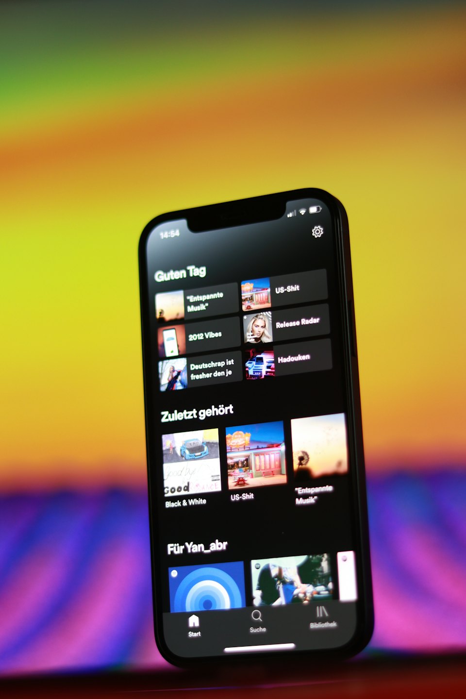 Black smartphone displaying a music streaming application with album art.